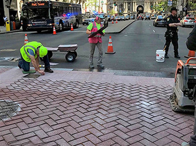 Workers applying TrafficPatternsXD brick pattern crosswalk in Philadelphia