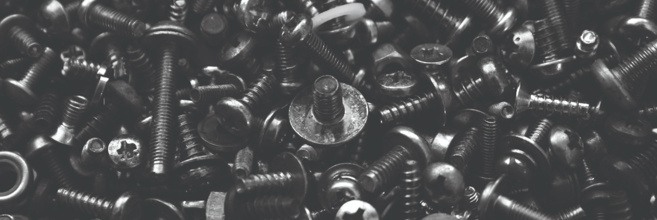 A close up view of a pile of black fasteners and small parts