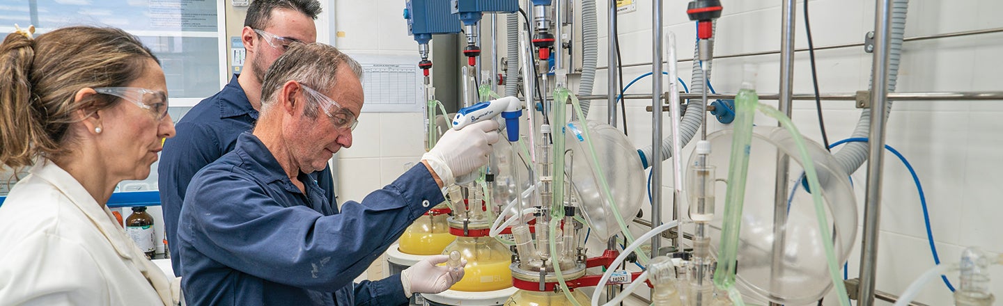 PPG employees wearing PPE inspecting equipment in laboratory 