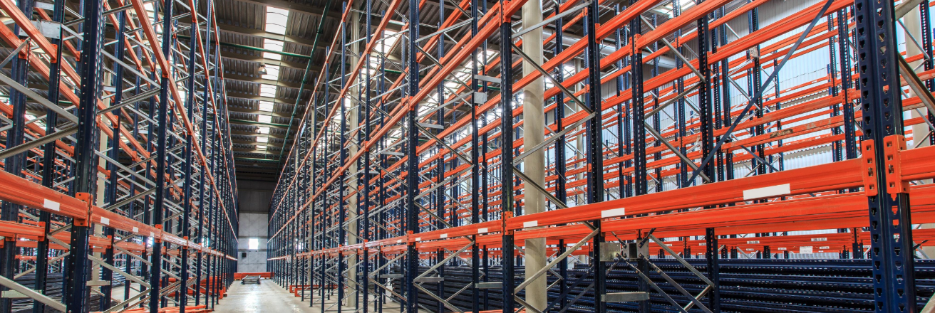 Long sets of empty red racking in a warehouse