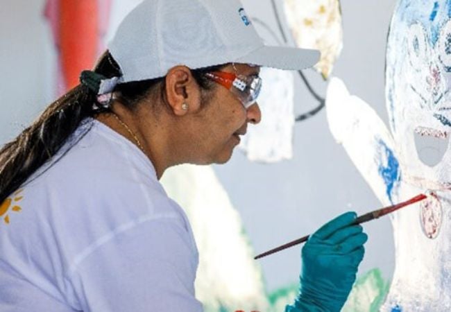 woman painting mural in Moraiya, India 