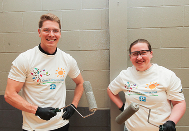 two volunteers holding paint rollers in Indianapolis, Indiana 