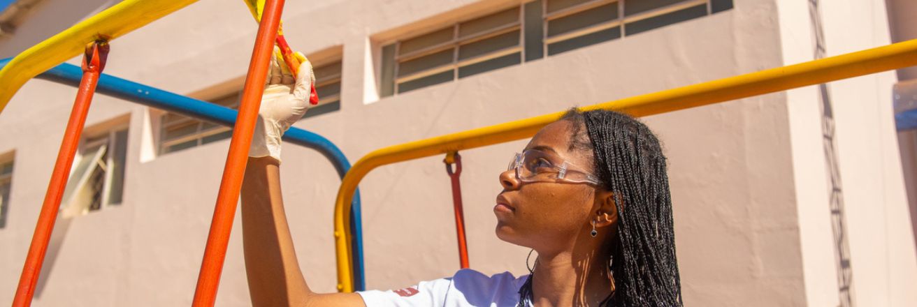 woman painting playground equipment