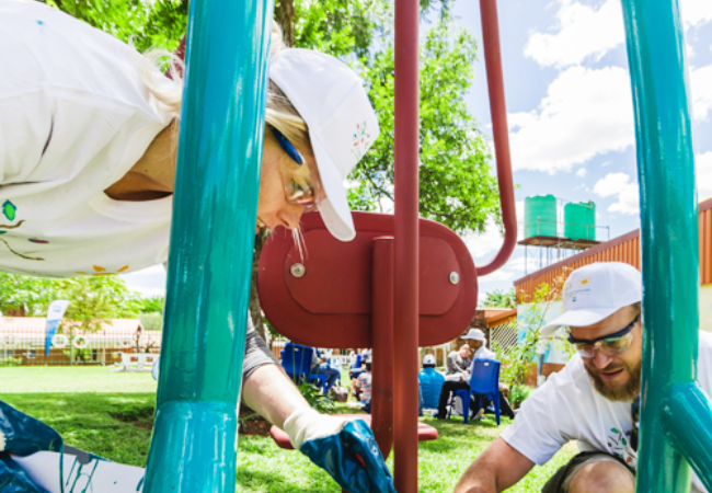 volunteers painting playground equipment 