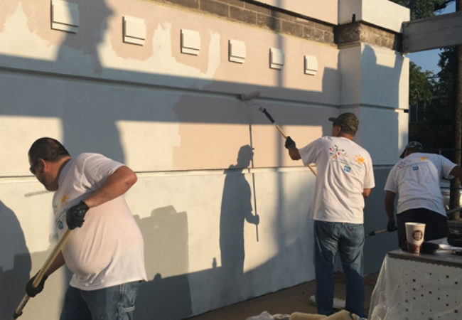 volunteers painting wall beige