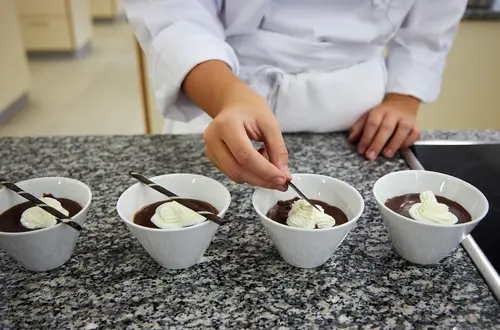 Schülerin beim anrichten eines Dessert Schülerin beim anrichten eines Dessert