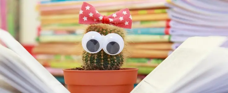 Kaktus mit Augen liest in Buch Kaktus mit Augen liest in Buch