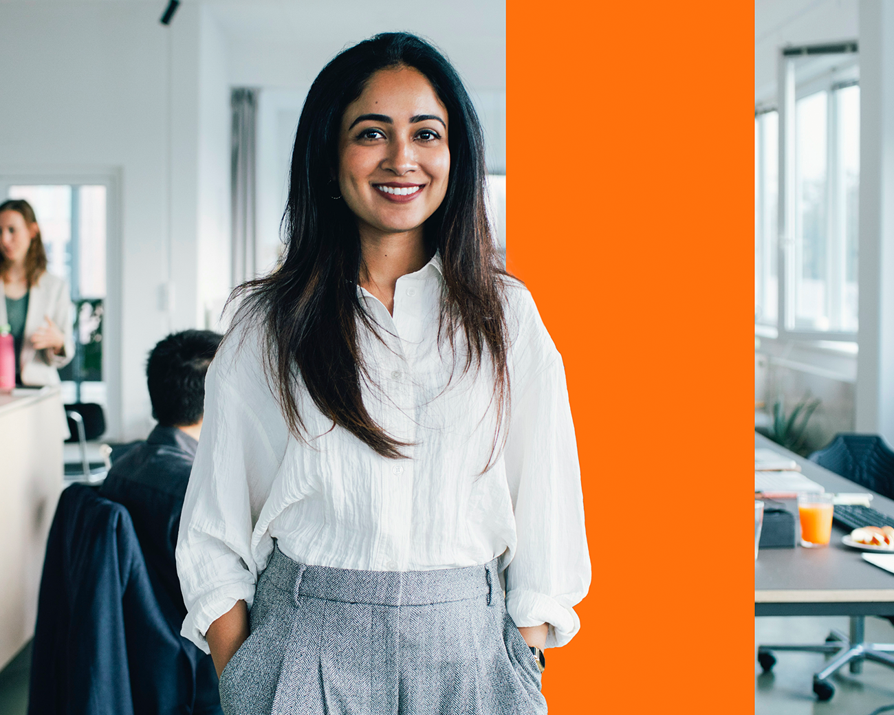 Lachende vrouw met handen in zakken