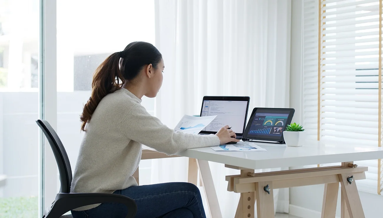 Achteraanzicht van jonge vrouw die werkt op een laptop