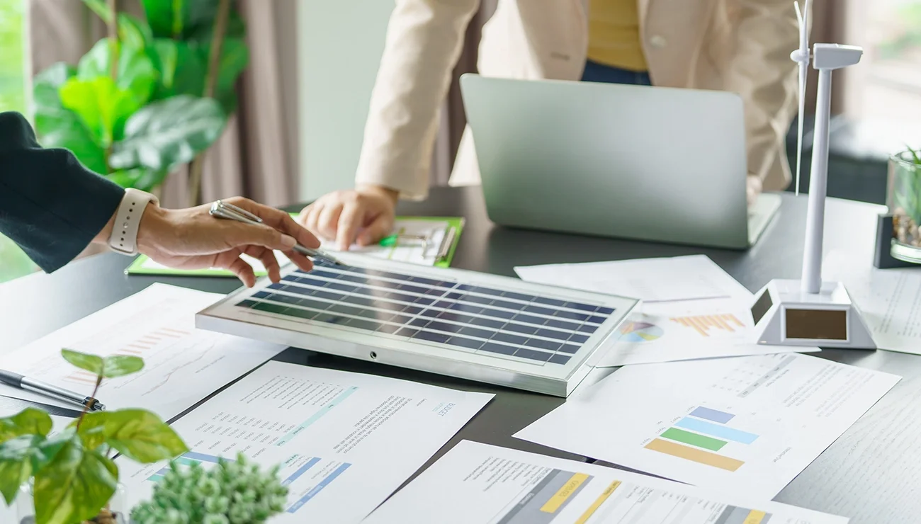 Mensen bestuderen schema’s op papier en werken tegelijkertijd op een laptop