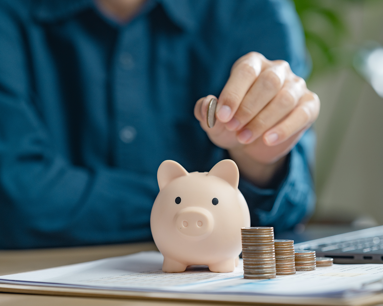 Man stopt geld in spaarvarken