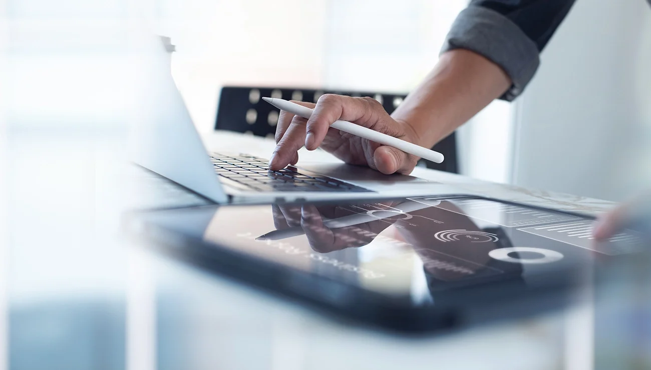 Persoon werkt op laptop en tablet