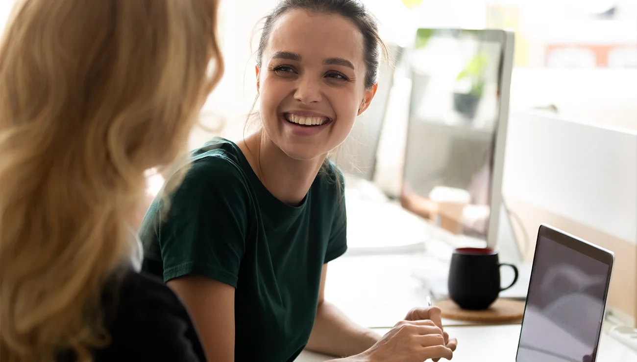Lachende marketing professionals bij laptop