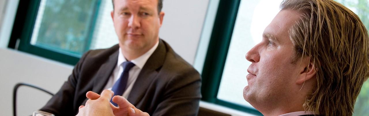 Twee mannen in gesprek in kantoorruimte