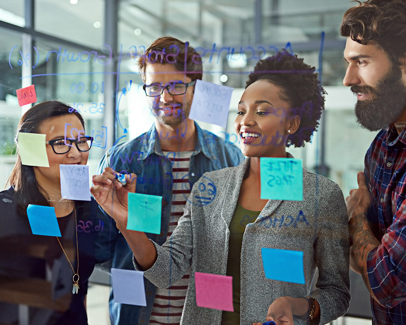 Collega's in brainstorm bij doorzichtig whiteboard met post-its