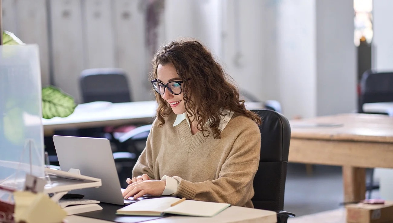 Recruitment Marketeer werkt op haar laptop in een kantooromgeving