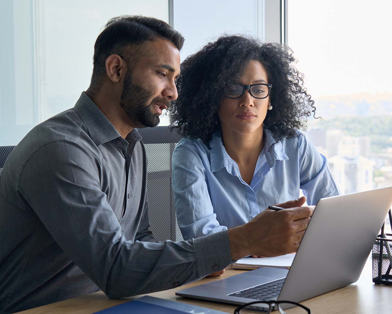 Man en vrouw zitten samen in kantoor achter laptop