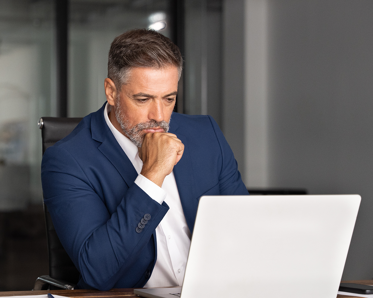 Zakenman in pak kijkt gefocust naar laptopscherm