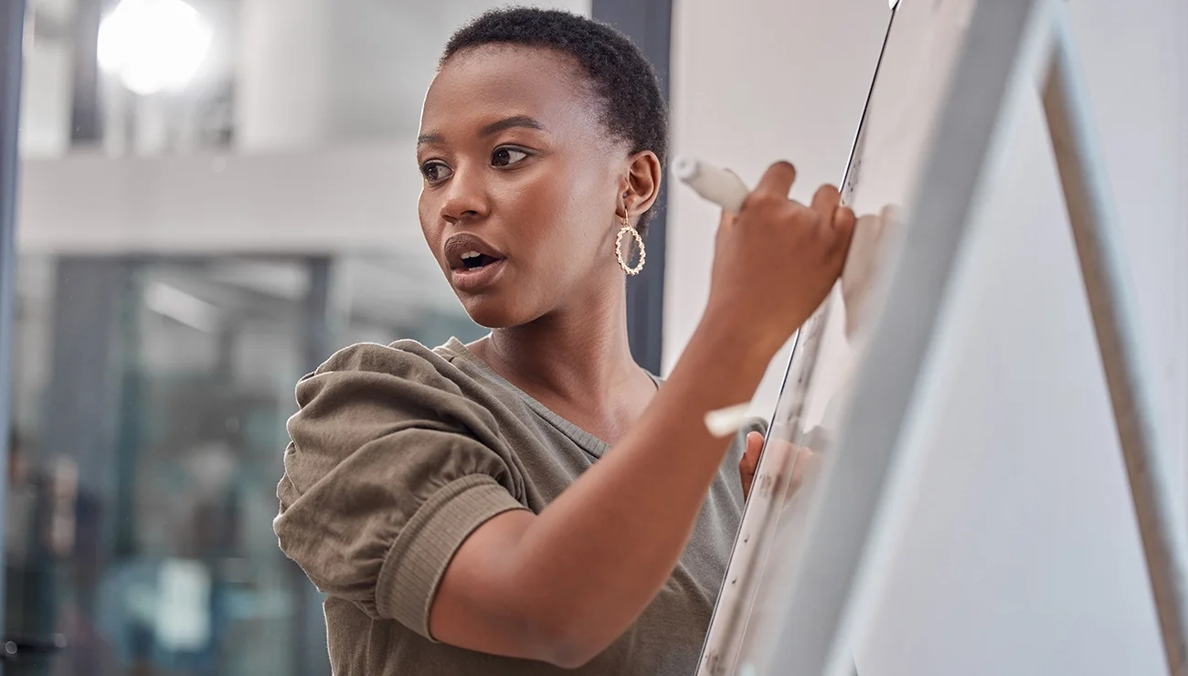 Vrouw maakt aantekeningen op een whiteboard