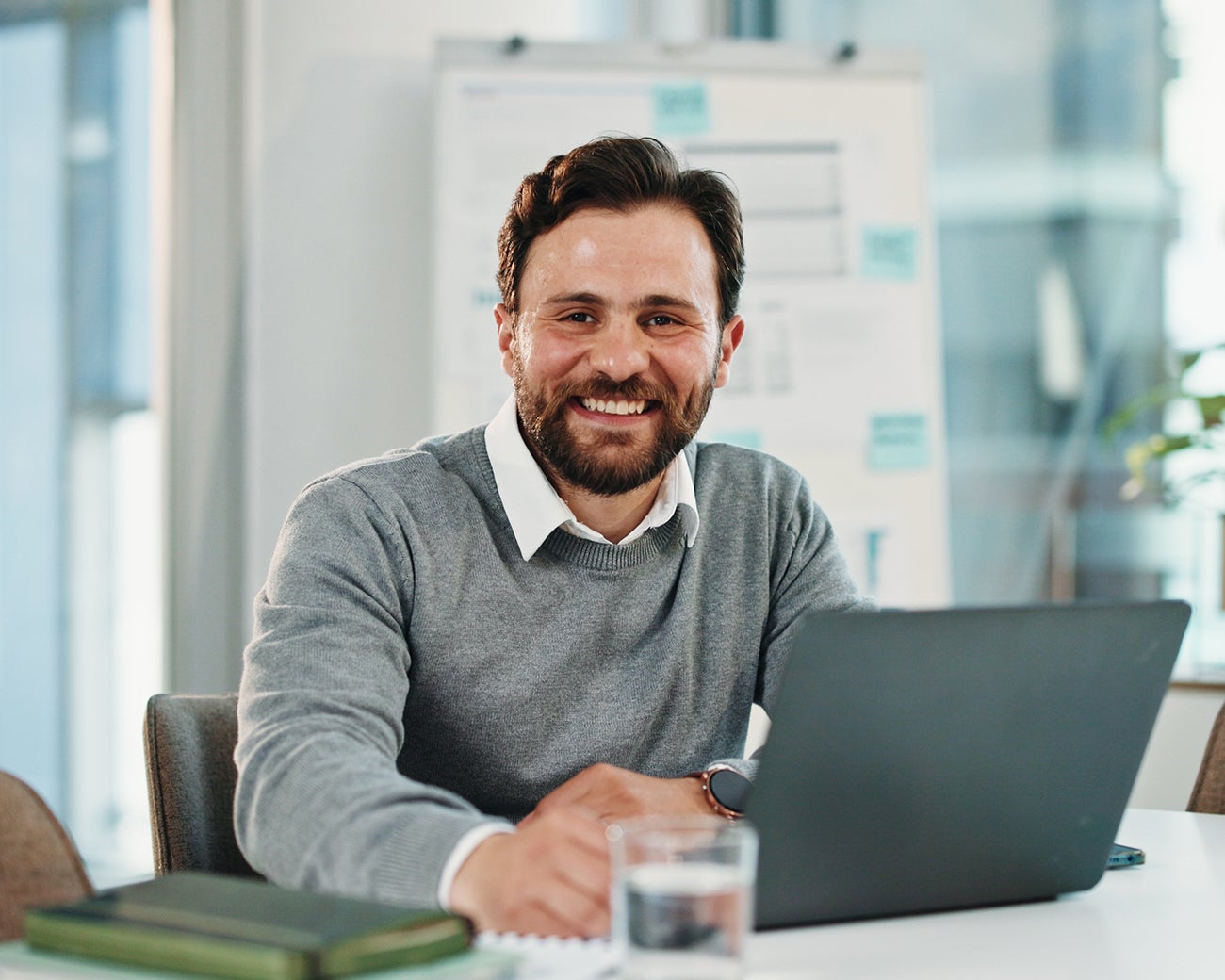 Lachende man achter laptop