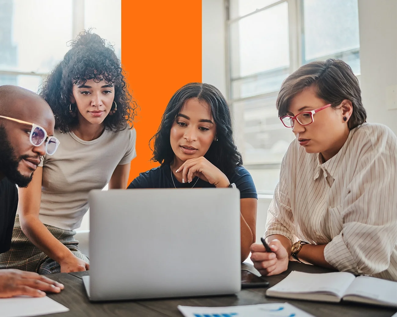 Mensen kijken naar laptopscherm op kantoor.