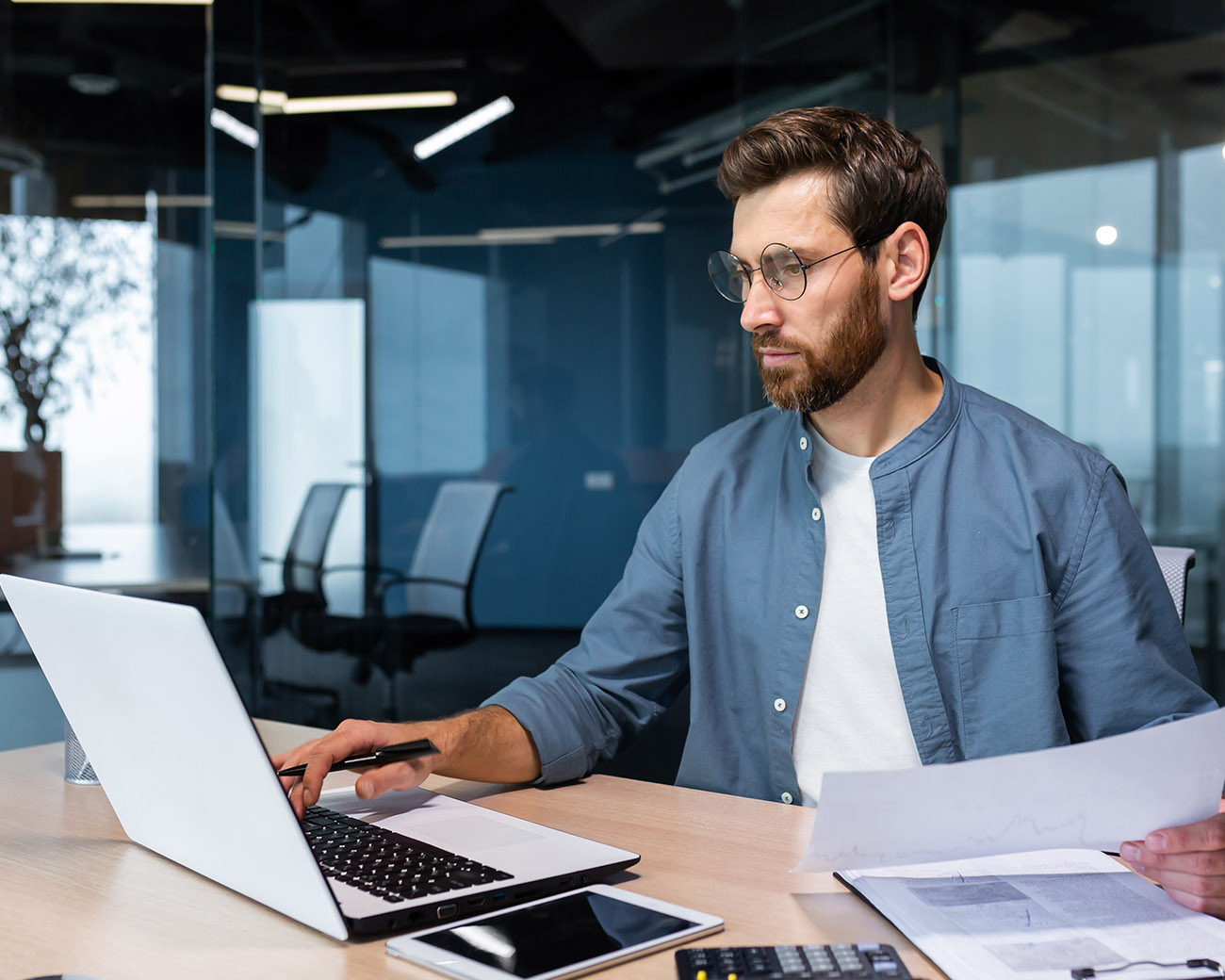man met laptop en papieren