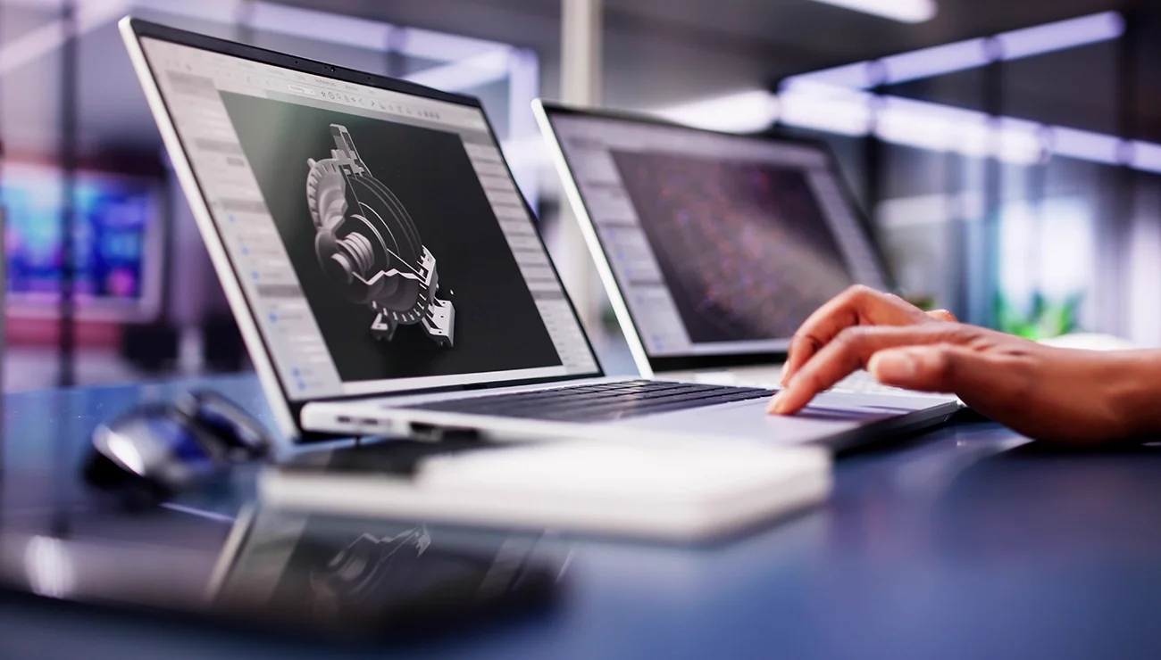 Persoon werkt achter een laptop en bekijkt een 3D-model op het scherm