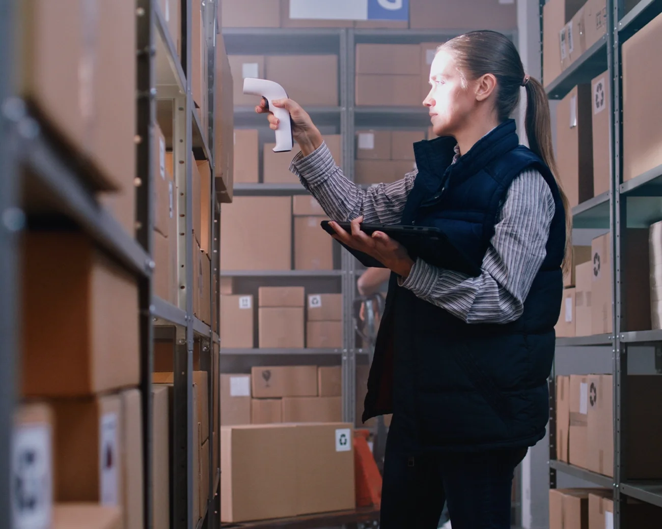 Logistiek medewerker scant pakket in magazijn