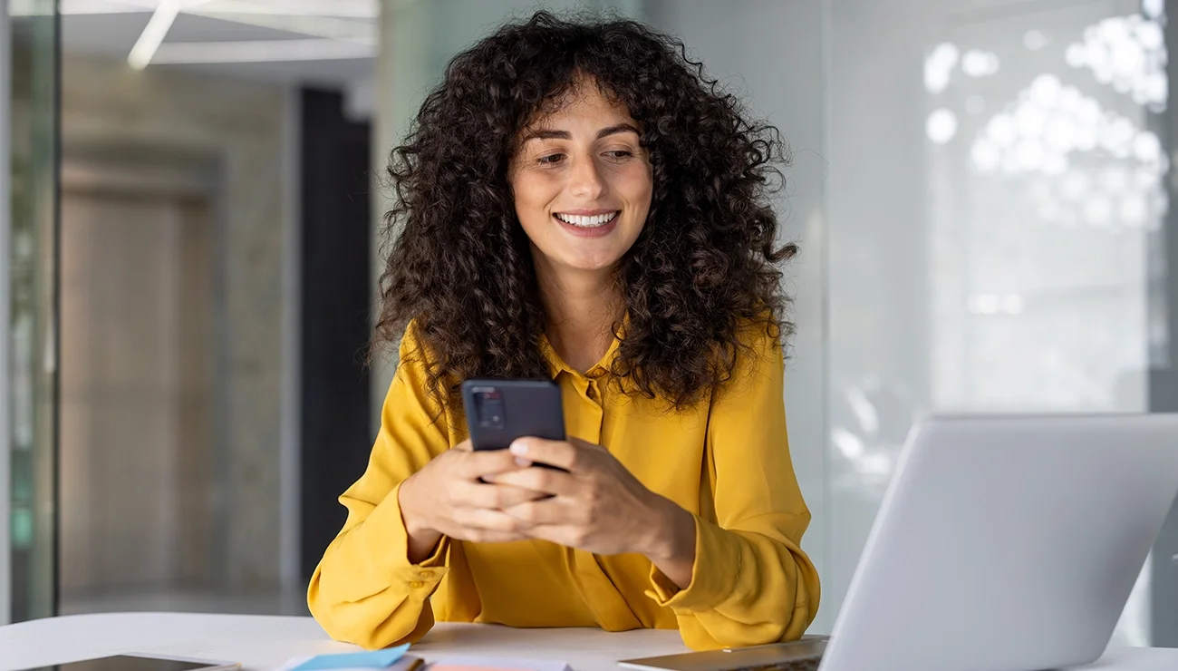 Vrouw achter haar telefoon en computer
