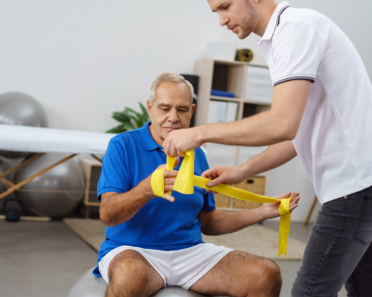 oudere man die hulp krijgt met elastiek