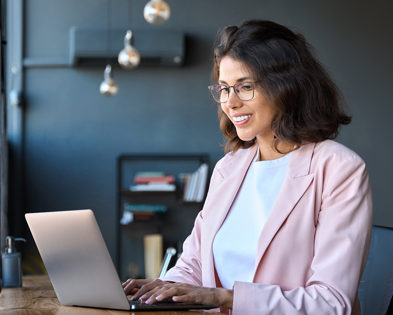 Vrouw lachend achter laptop