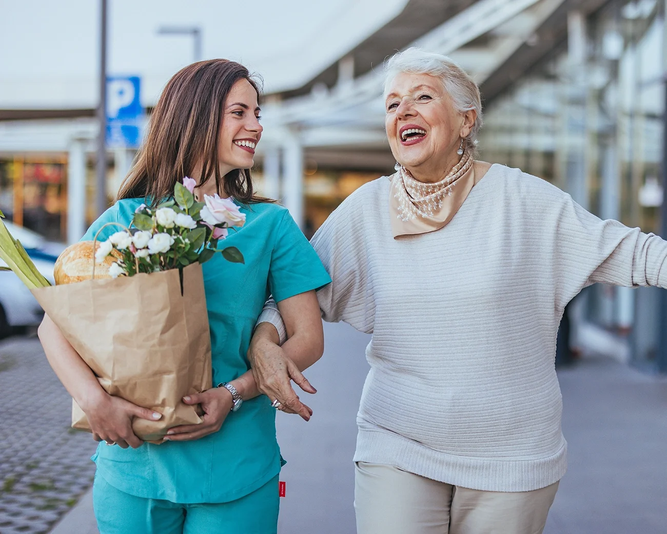 Zorgprofessional draagt boodschappen voor vrolijke oudere vrouw