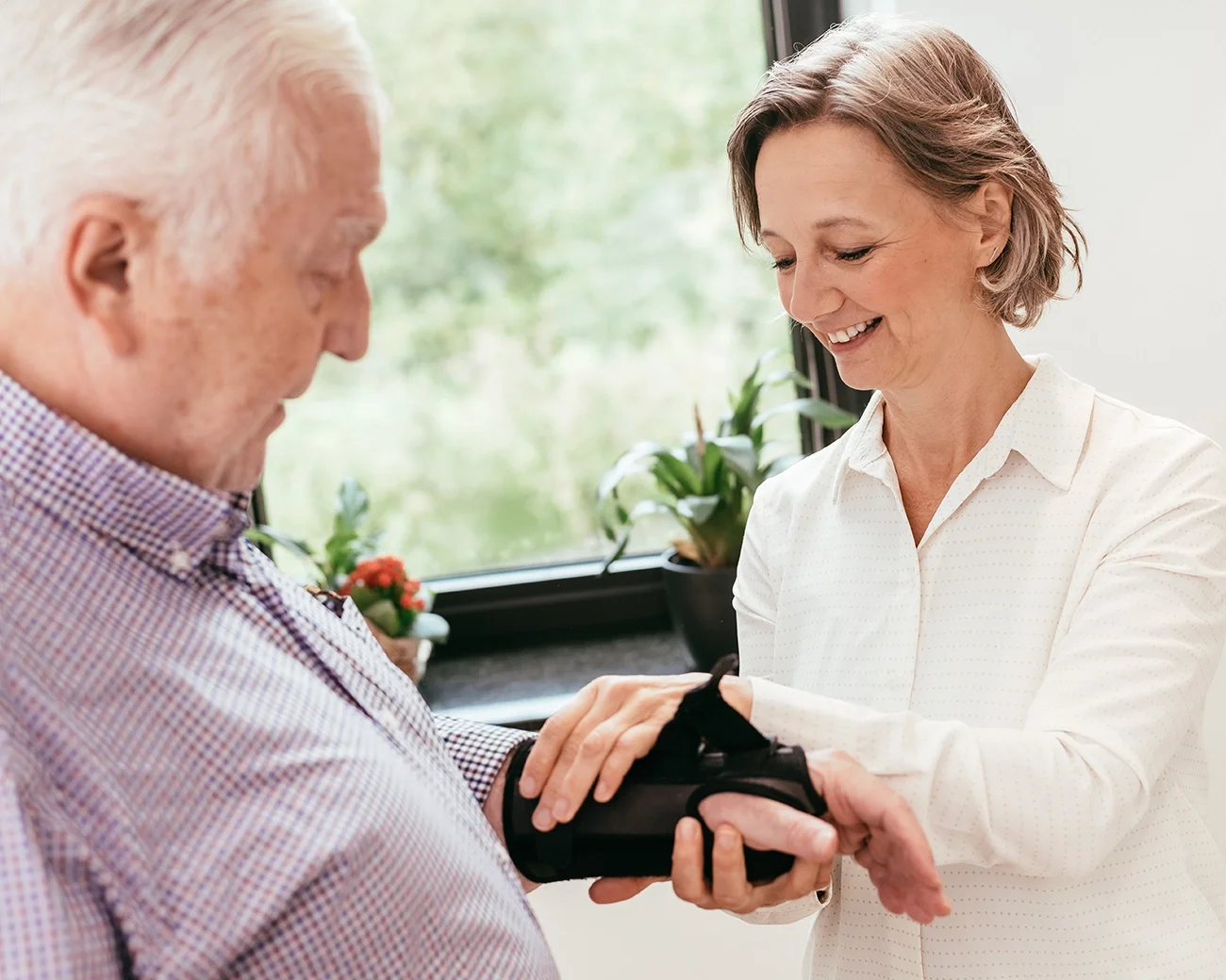 Verzorger doet handspalk om bij oude man
