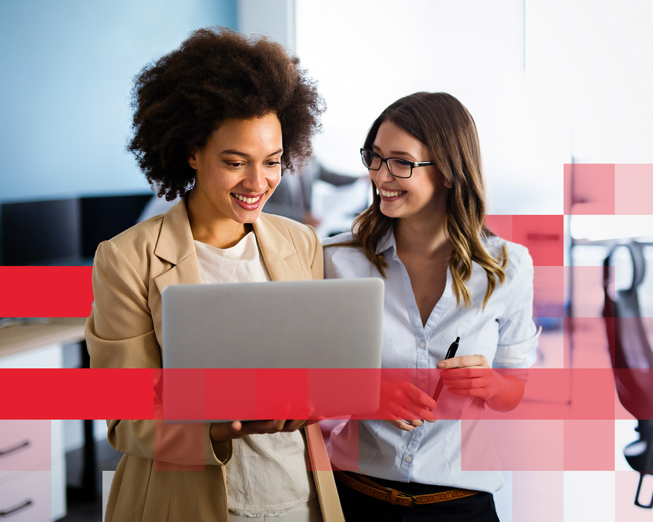 2 vrouwelijke collega's kijken naar een laptop