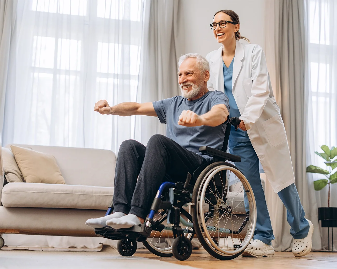 Fysiotherapeute duwt blije man in rolstoel