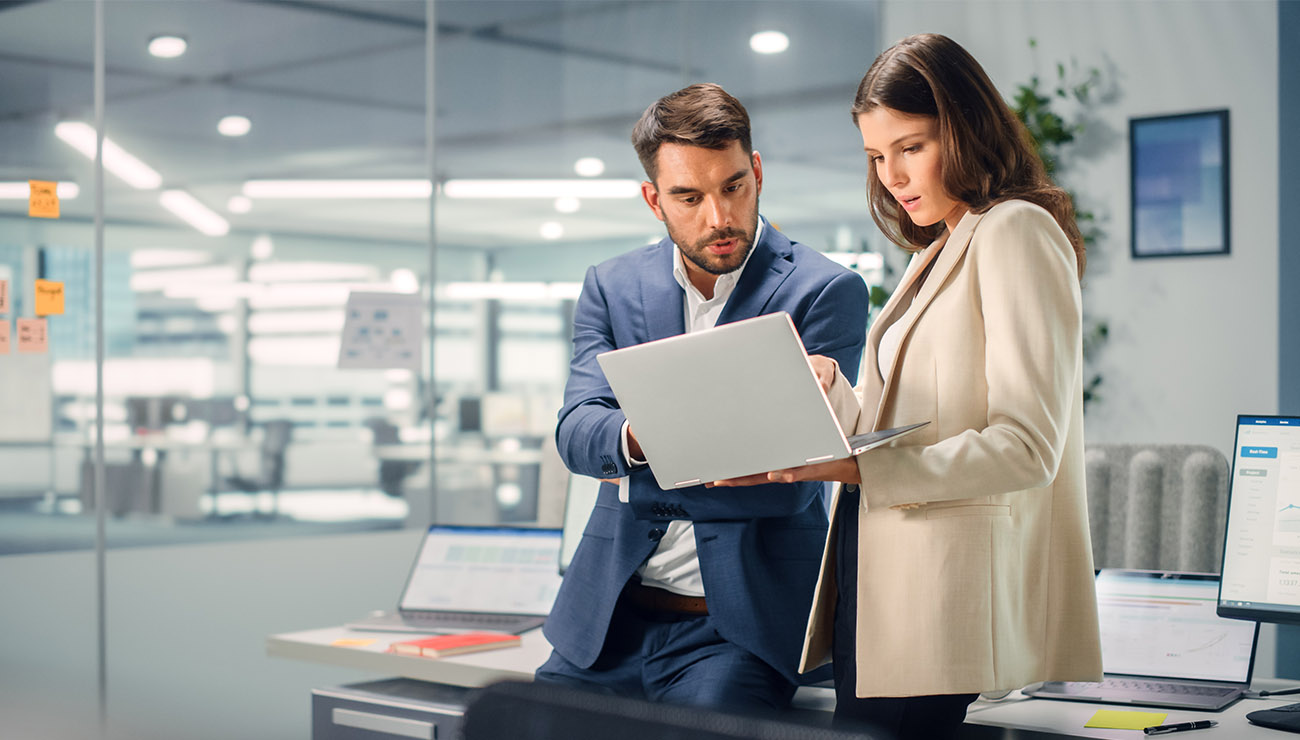 staande man en vrouw in kantoor met laptop