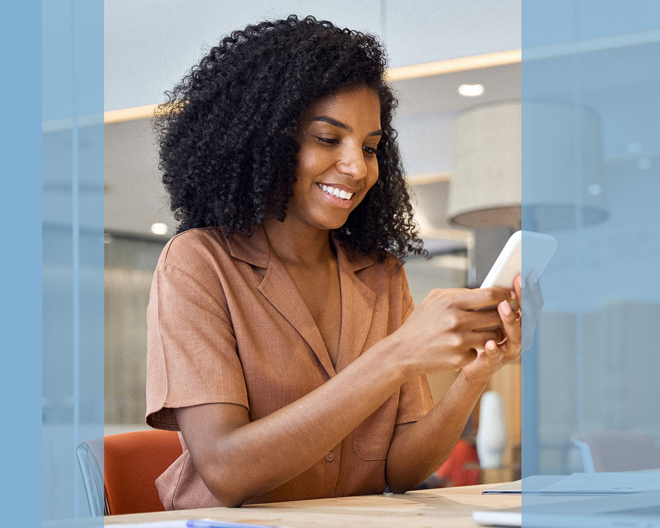 co-manager kijkt op smartphone in kantooromgeving