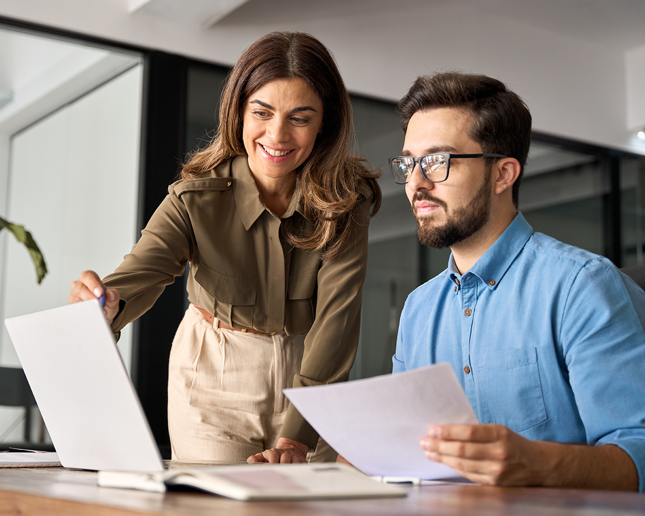 man en vrouw die samen overleggen en naar een laptop kijken.