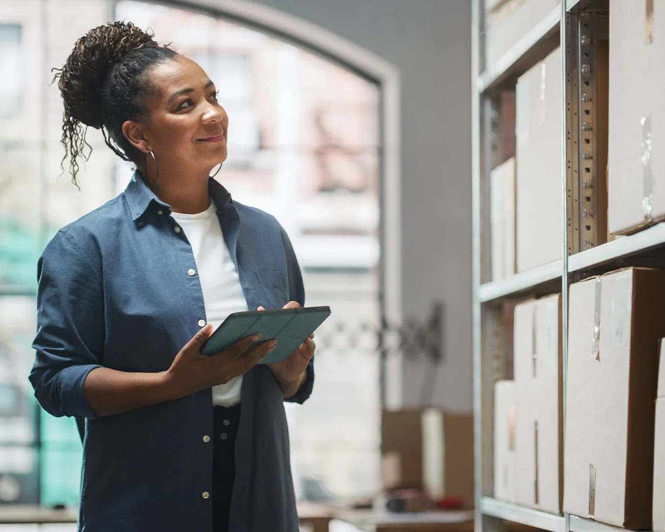 Lachende vrouw met tablet in magazijn