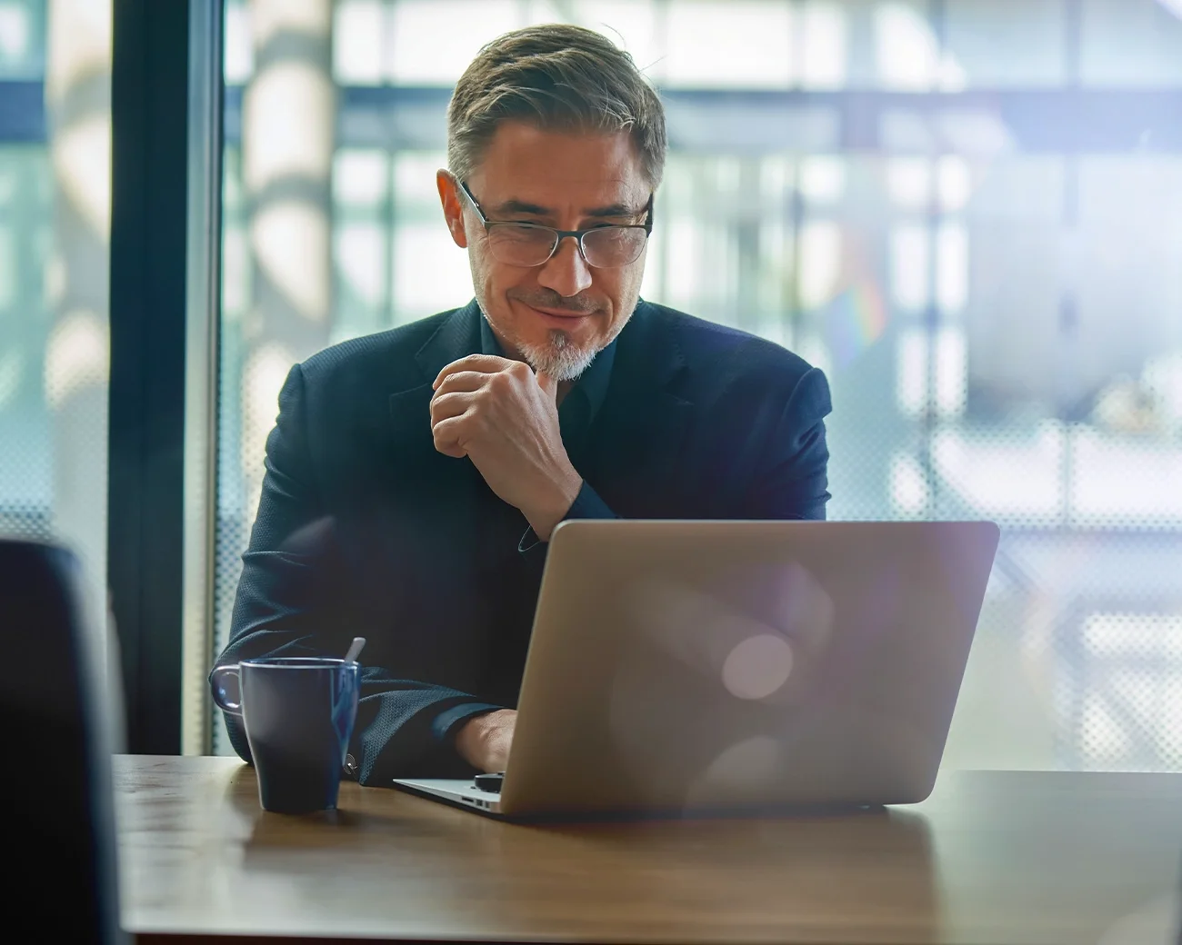 Man glimlacht achter laptop