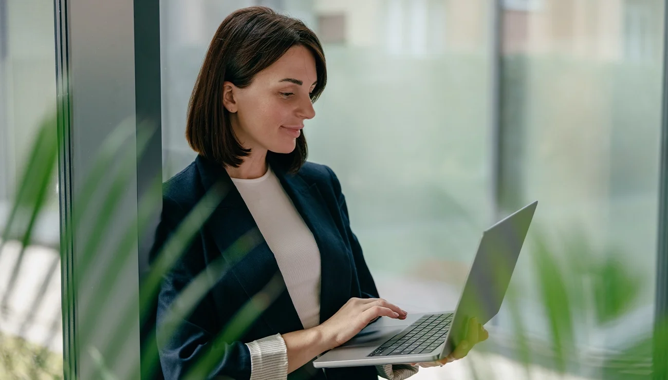 Vrouw werkt staand op haar laptop