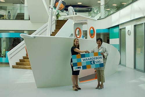 Twee vrouwen in grote hal met waardecheque van €500,-