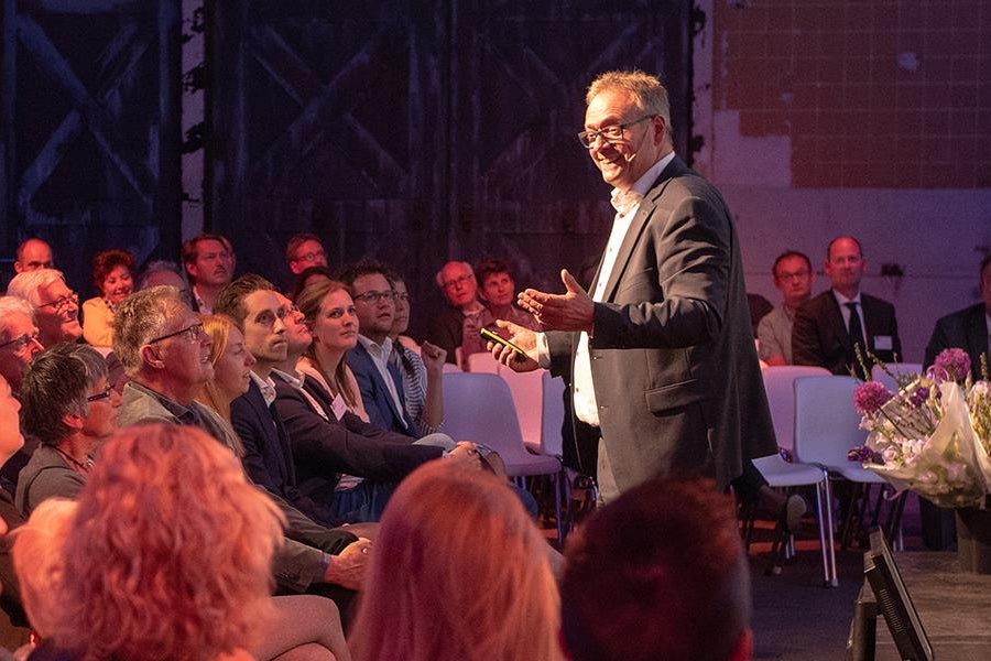 Spreker omringd door publiek op Financials Dinner