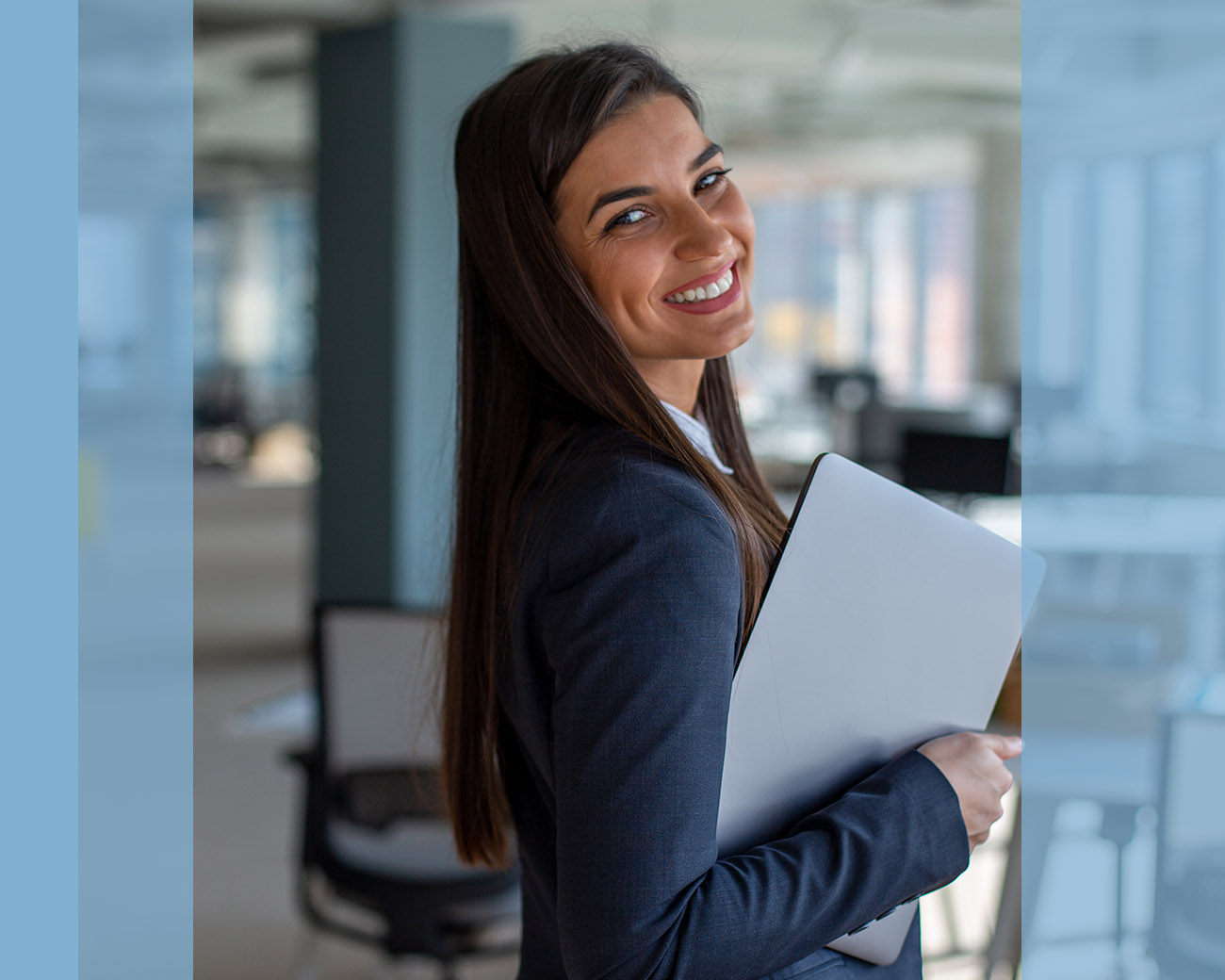 Een lachende officemanager op kantoor met laptop