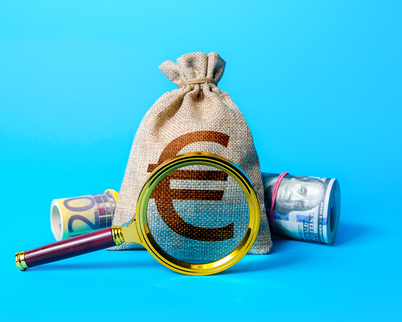 Zak geld met vergrootglas ervoor