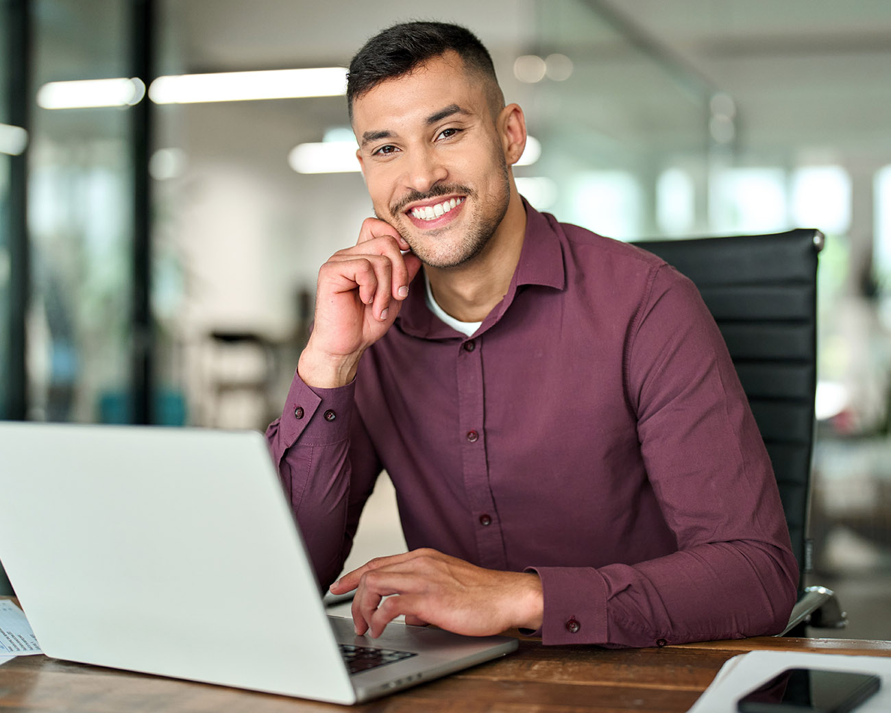 Glimlachende man achter laptop