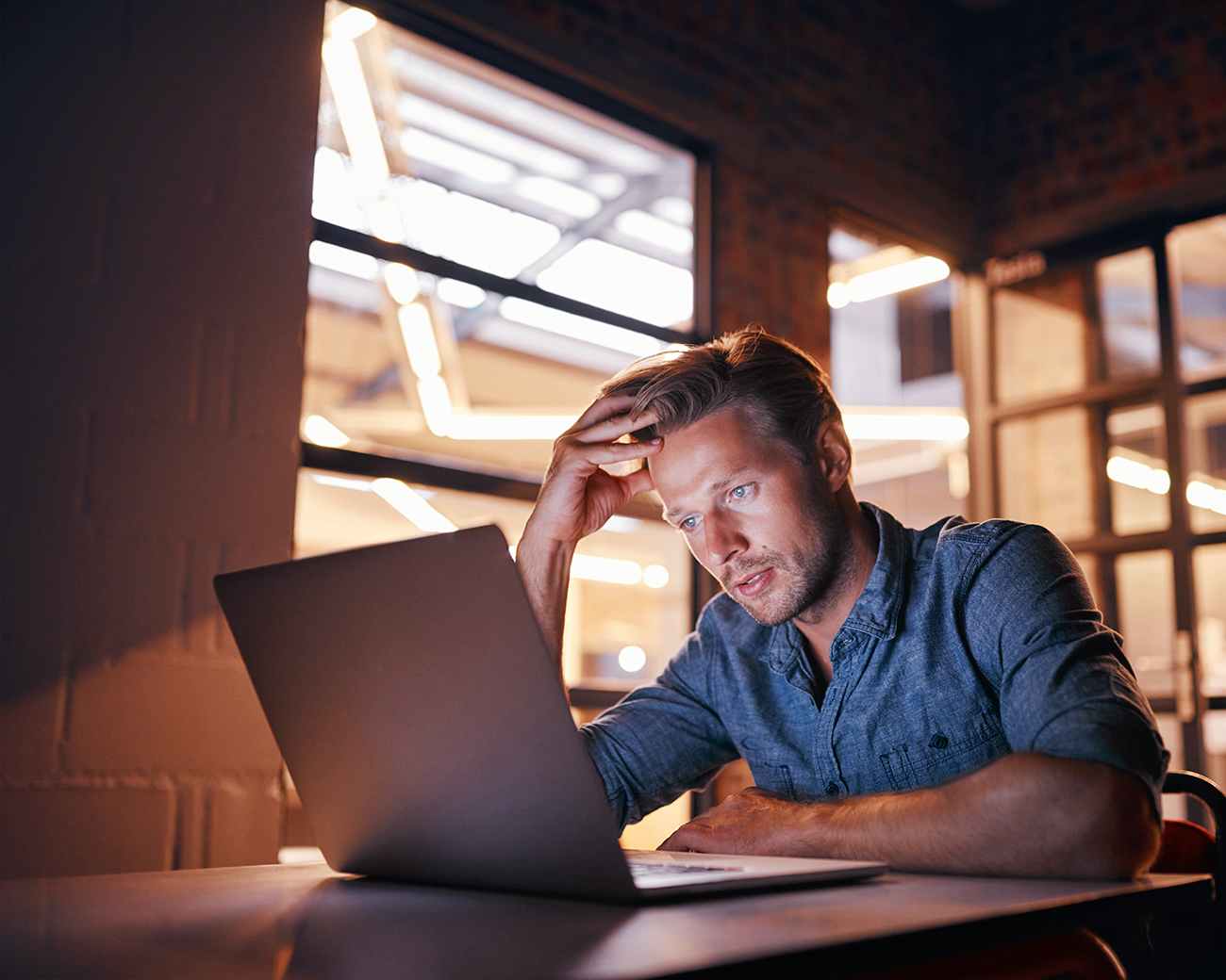 Man achter laptop aan het nadenken