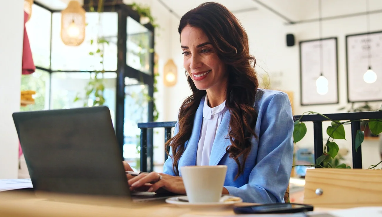 Een vrolijke vrouw achter een laptop