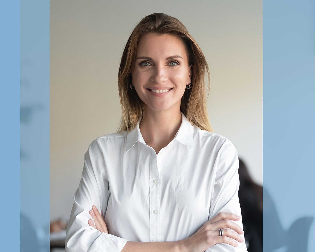 Officemanager kijkt lachend met gekruiste armen