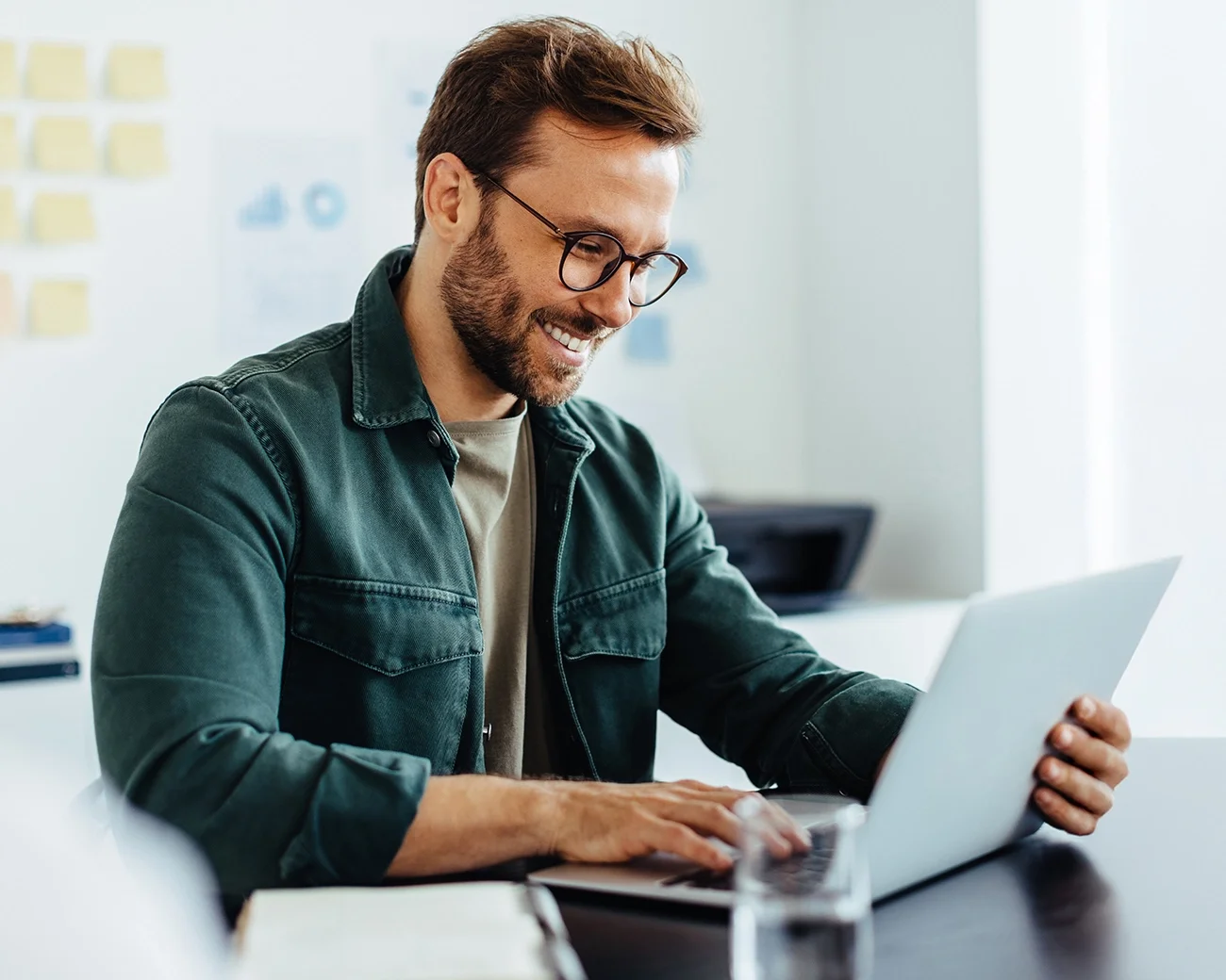 Man lachend achter laptop